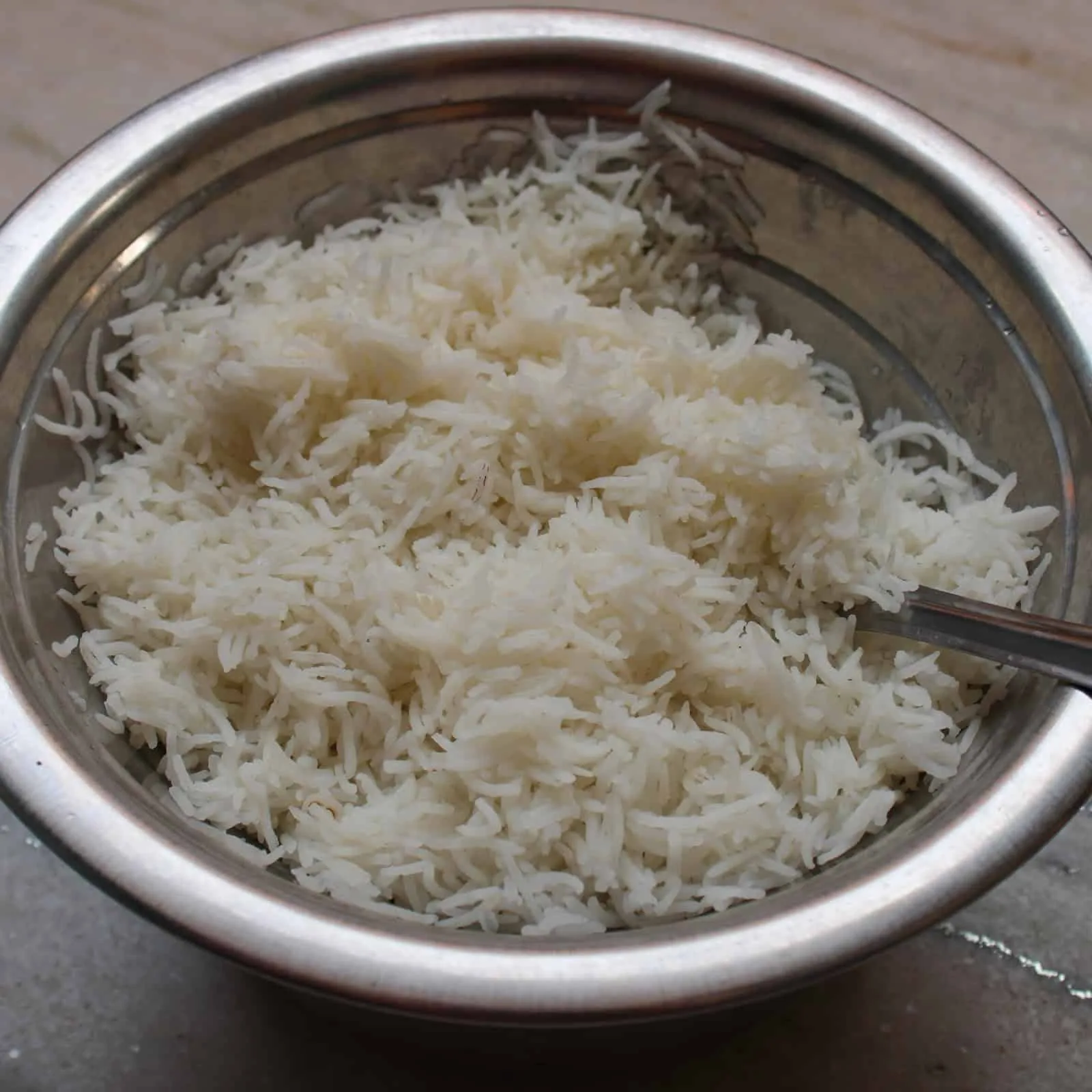 fluffy basmati rice in steel bowl with spoon jpeg